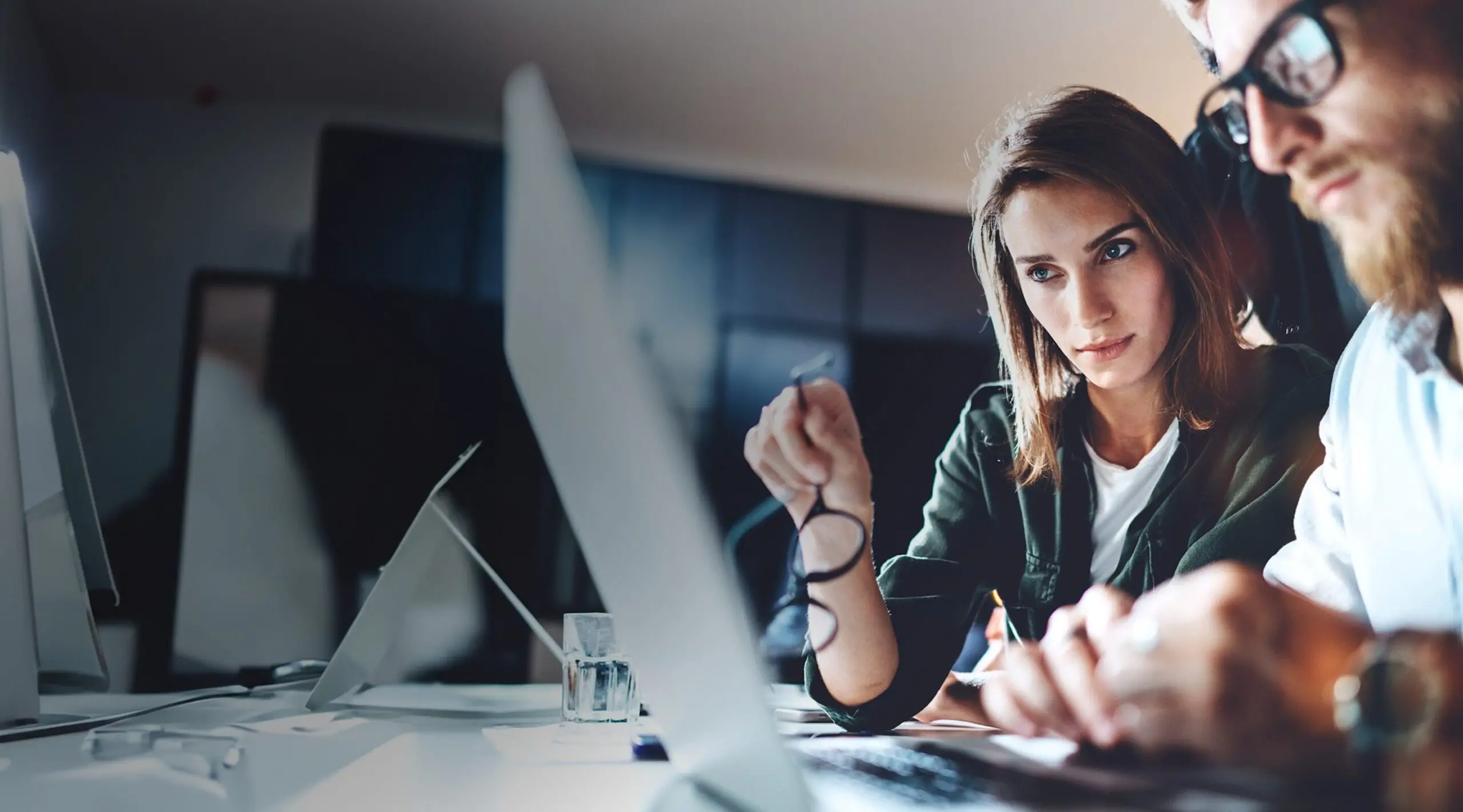 Leerink Partners Equity Research, smart woman and male with glasses looking at a computer screen as they analyze a deal